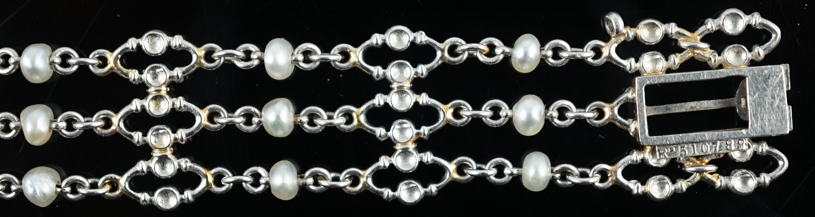 An early to mid 20th century white gold and seed pearl set three row chain link bracelet